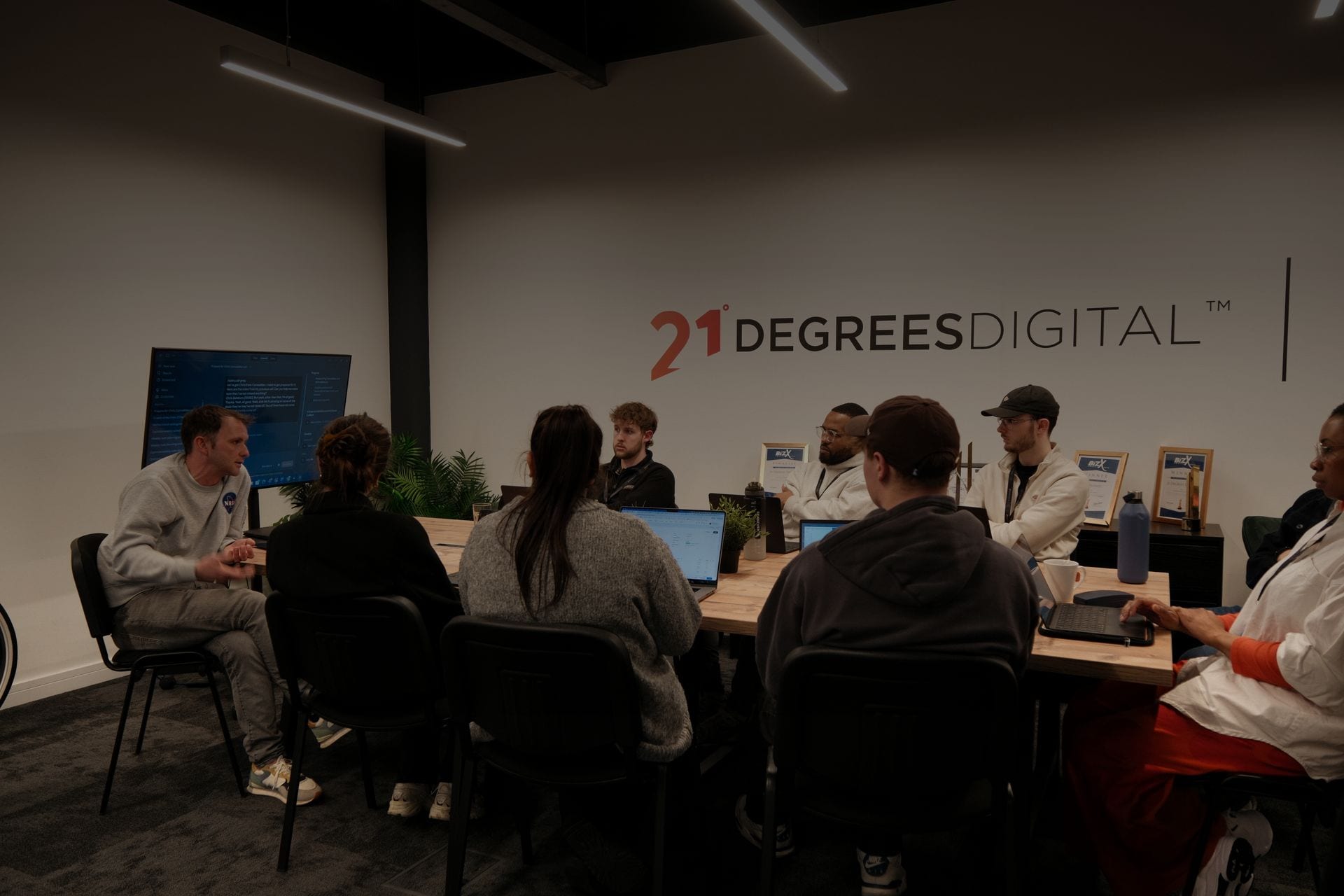 The 21 Degrees Digital team working together around the studio table at the Leeds office.