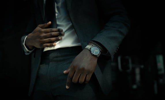 A suited man wearing an En Vogue watch.