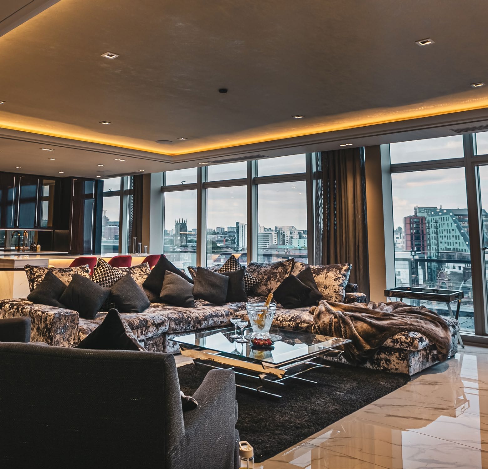 A penthouse living room with city skyline views, from the Urbane Lettings brand imagery
