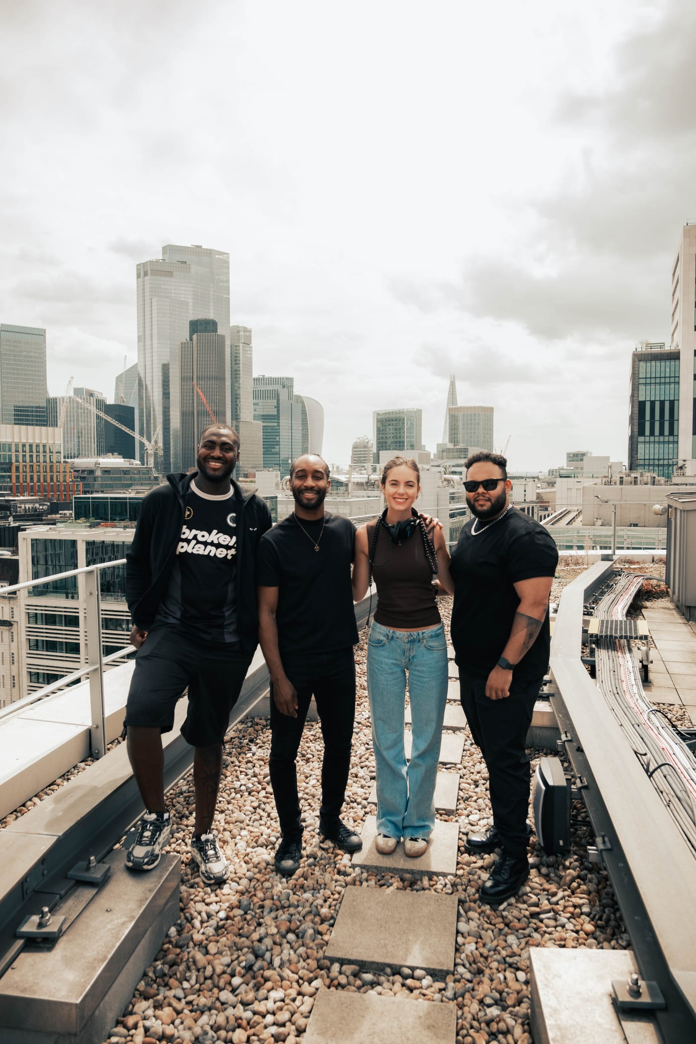 Four 21 Degrees team members standing together on a city rooftop with the skyline behind them.