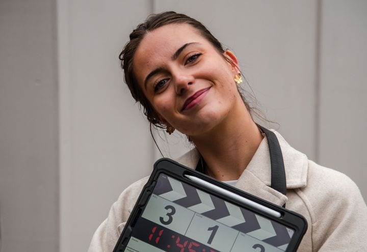 A 21 Degrees team member holding a clapperboard on a shoot.