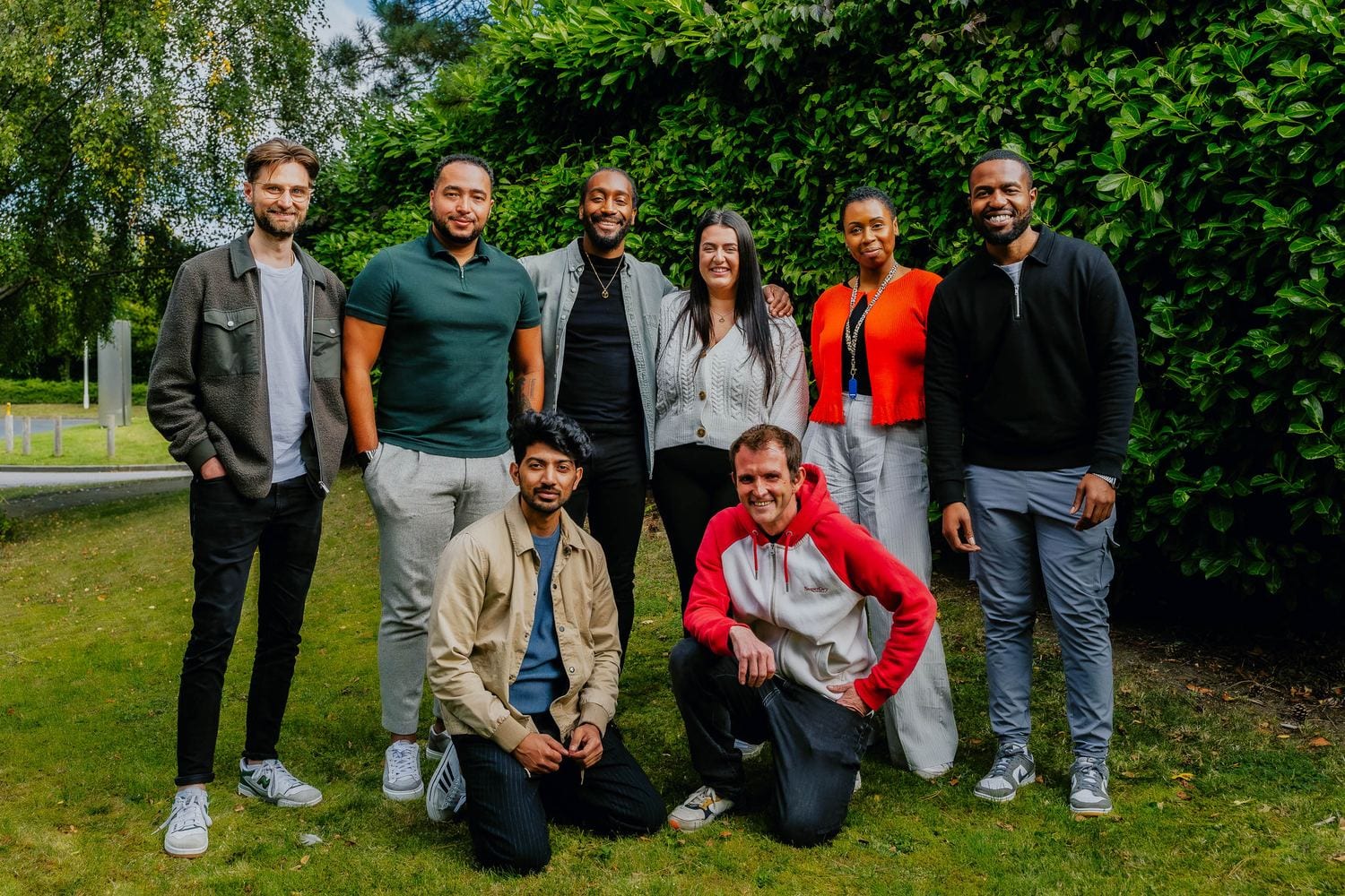 The 21 Degrees team together outdoors among greenery, smiling for the camera.